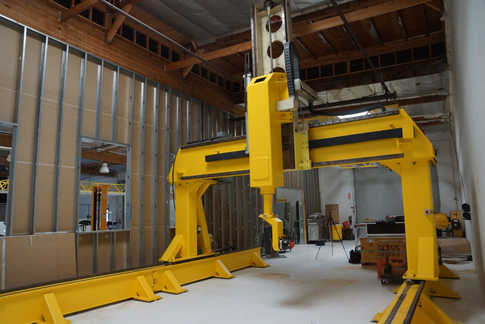 The large yellow 5-axis CNC router gantry on its rails, installed at a previous owner’s location