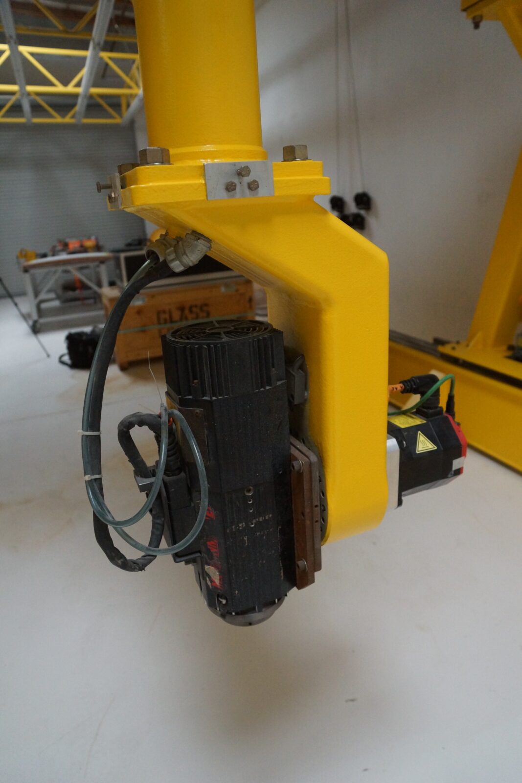 Close-up of the 5-axis head on the machine, with the spindle mounted on the yellow rotary arm